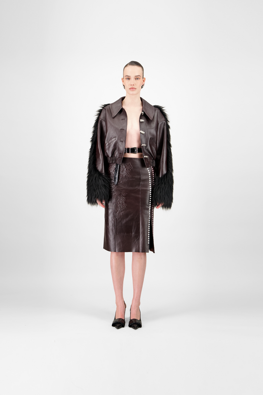 women wearing a dark brown leather outfit with a jacket and skirt