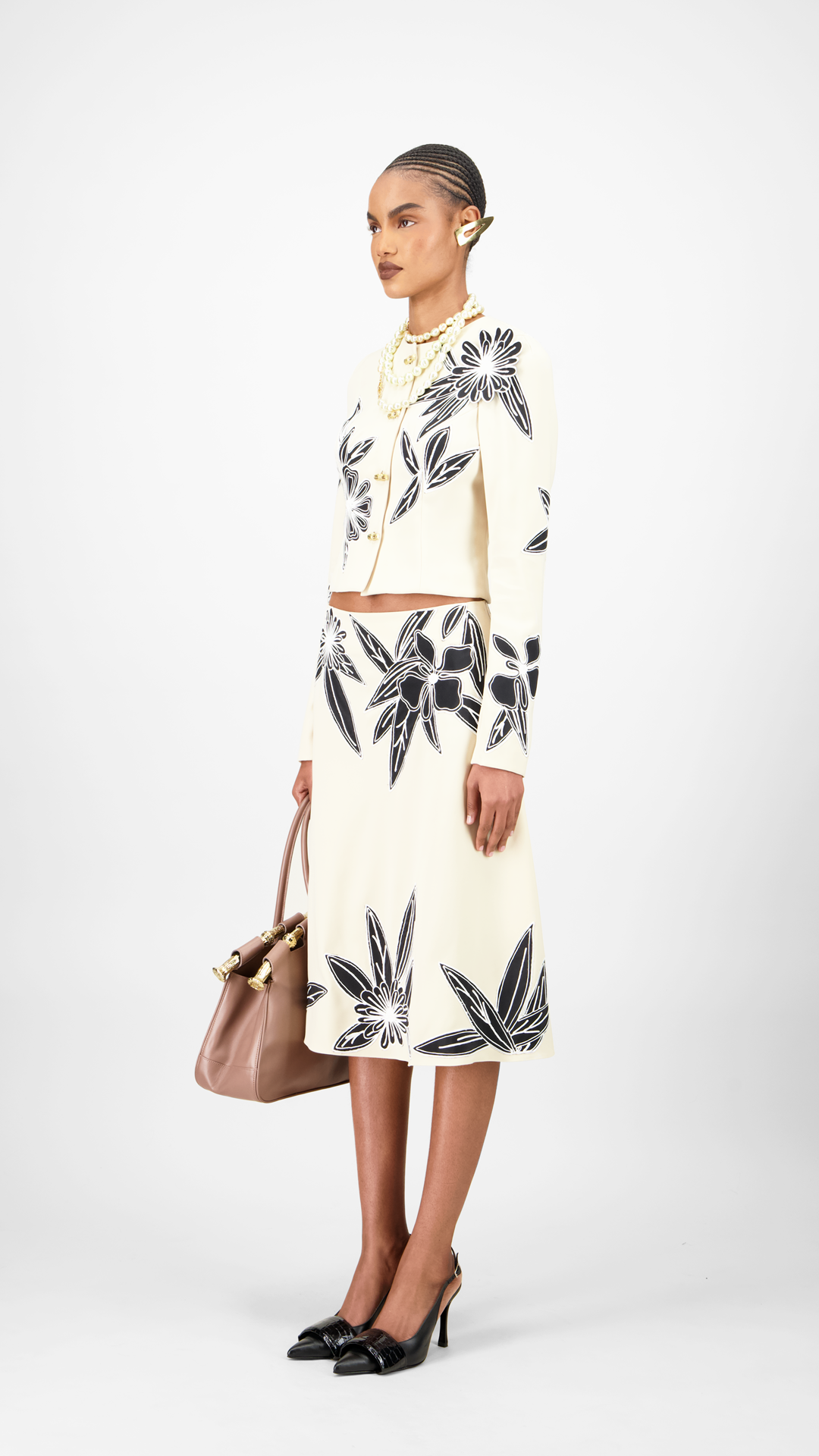Woman wearing a leaf-patterned set jacket and skirt