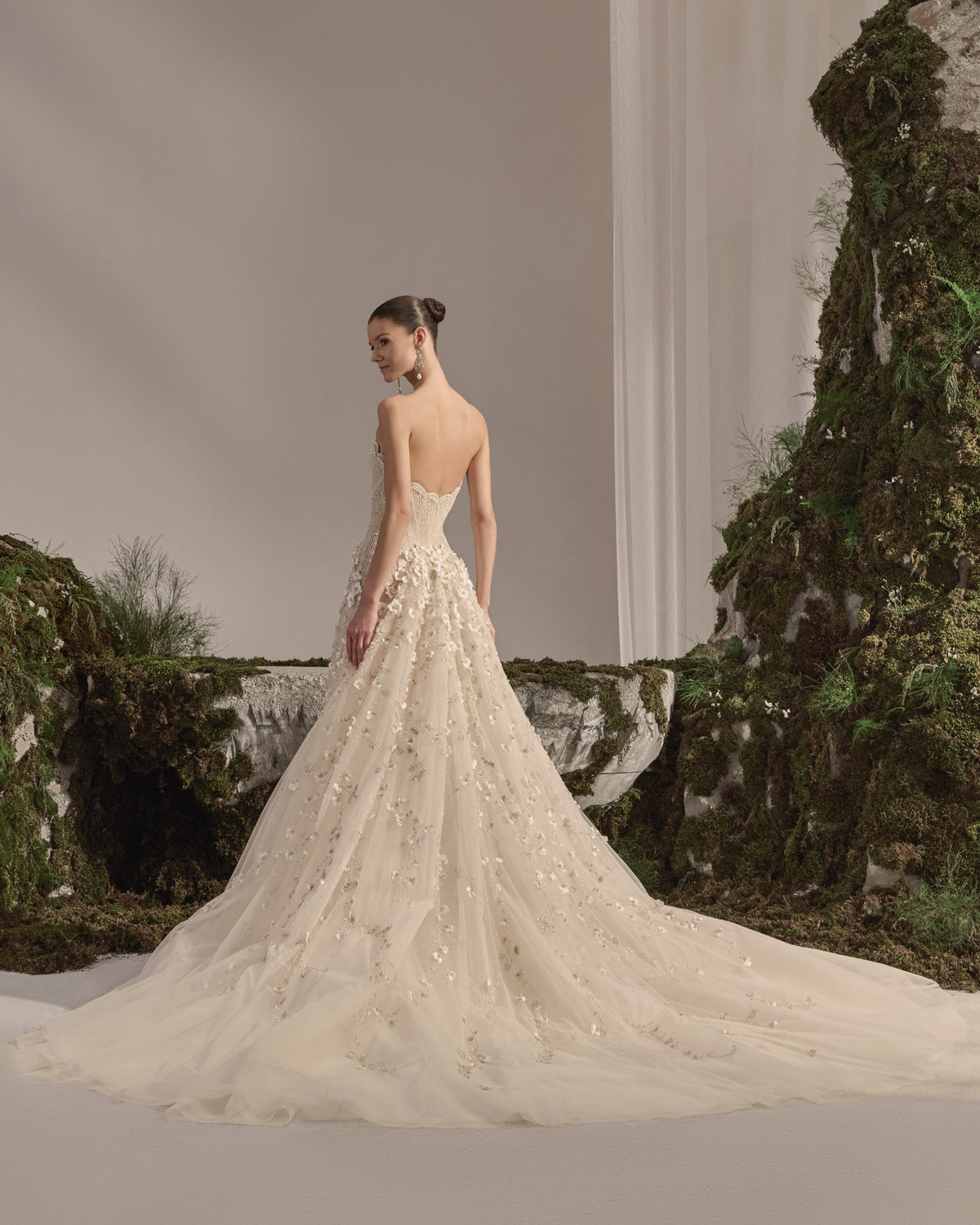Strapless bridal gown with an embellished sculpted corset bodice, floral appliqué tulle skirt and sheer veil.
