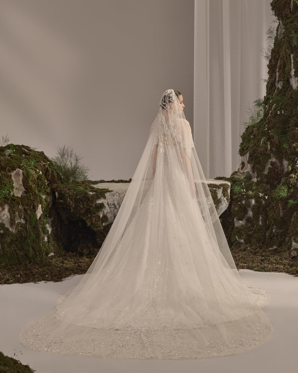 Embellished fitted bridal gown with a detachable sheer embroidered bolero and flowing veil.