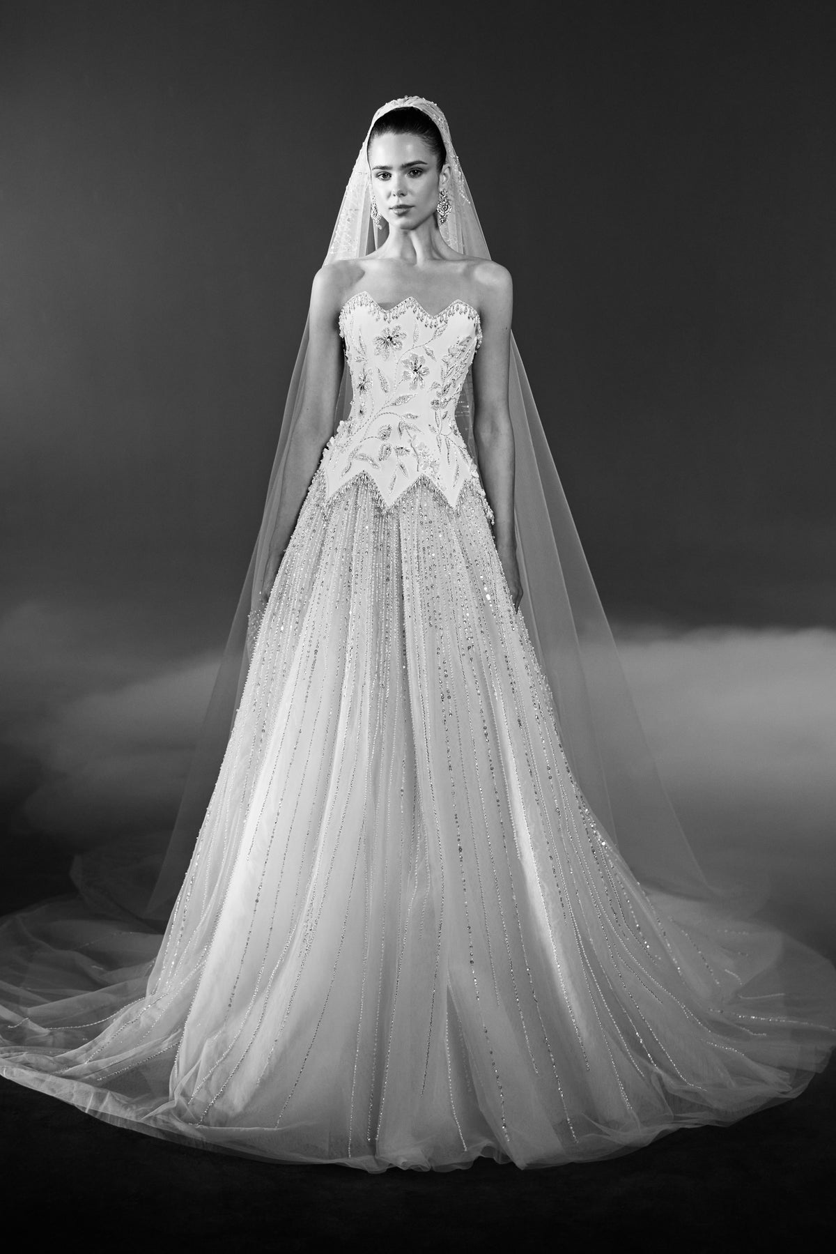 Off-white strapless bridal gown with floral embroidered bodice, embellished tulle skirt and long matching veil.