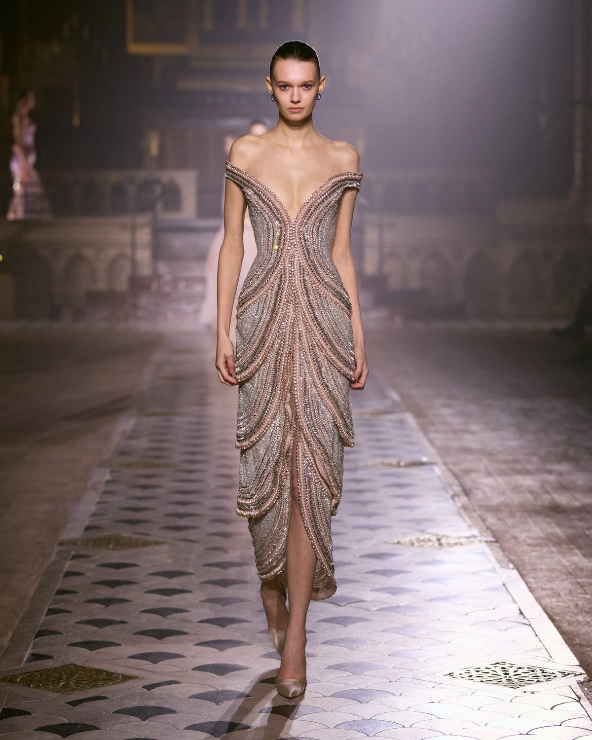 Blush pink off-shoulder couture dress with sculpted crystal embellishment and fitted silhouette.