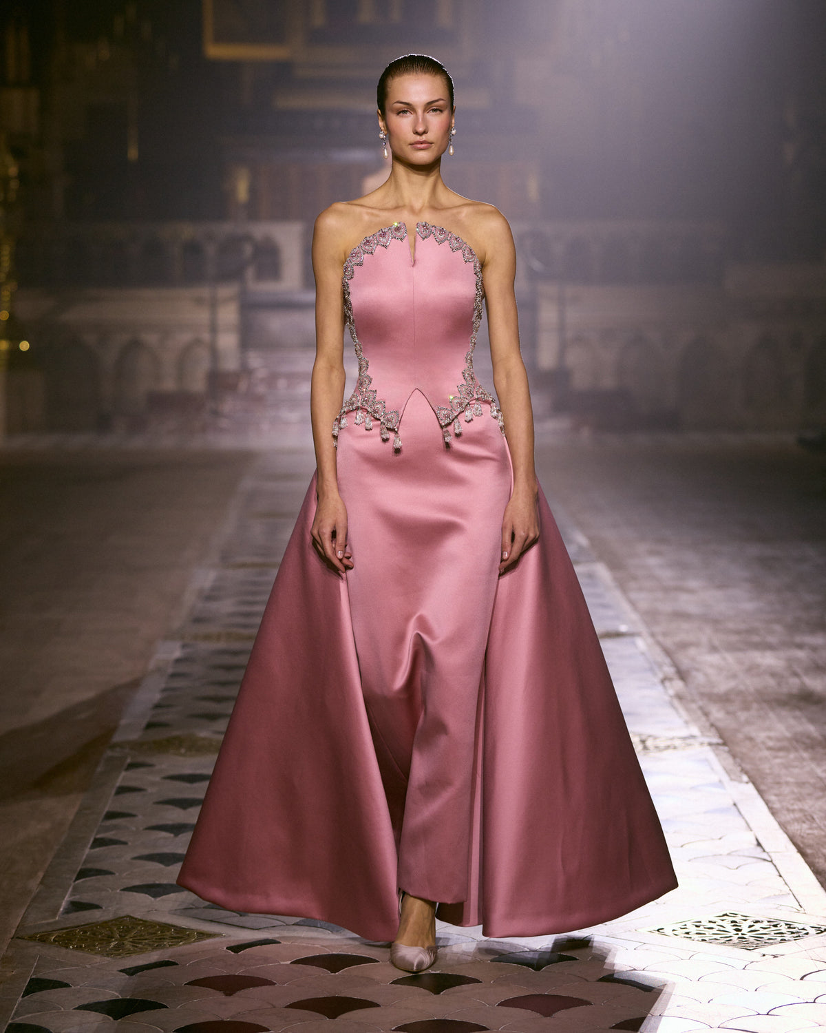 Rose pink satin couture gown with crystal embellishments and sculpted overskirt.