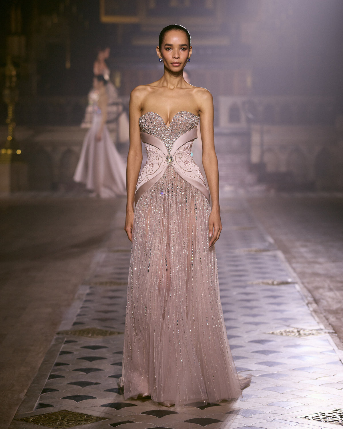 Blush pink strapless couture gown with crystal-embellished bodice and flowing beaded skirt.