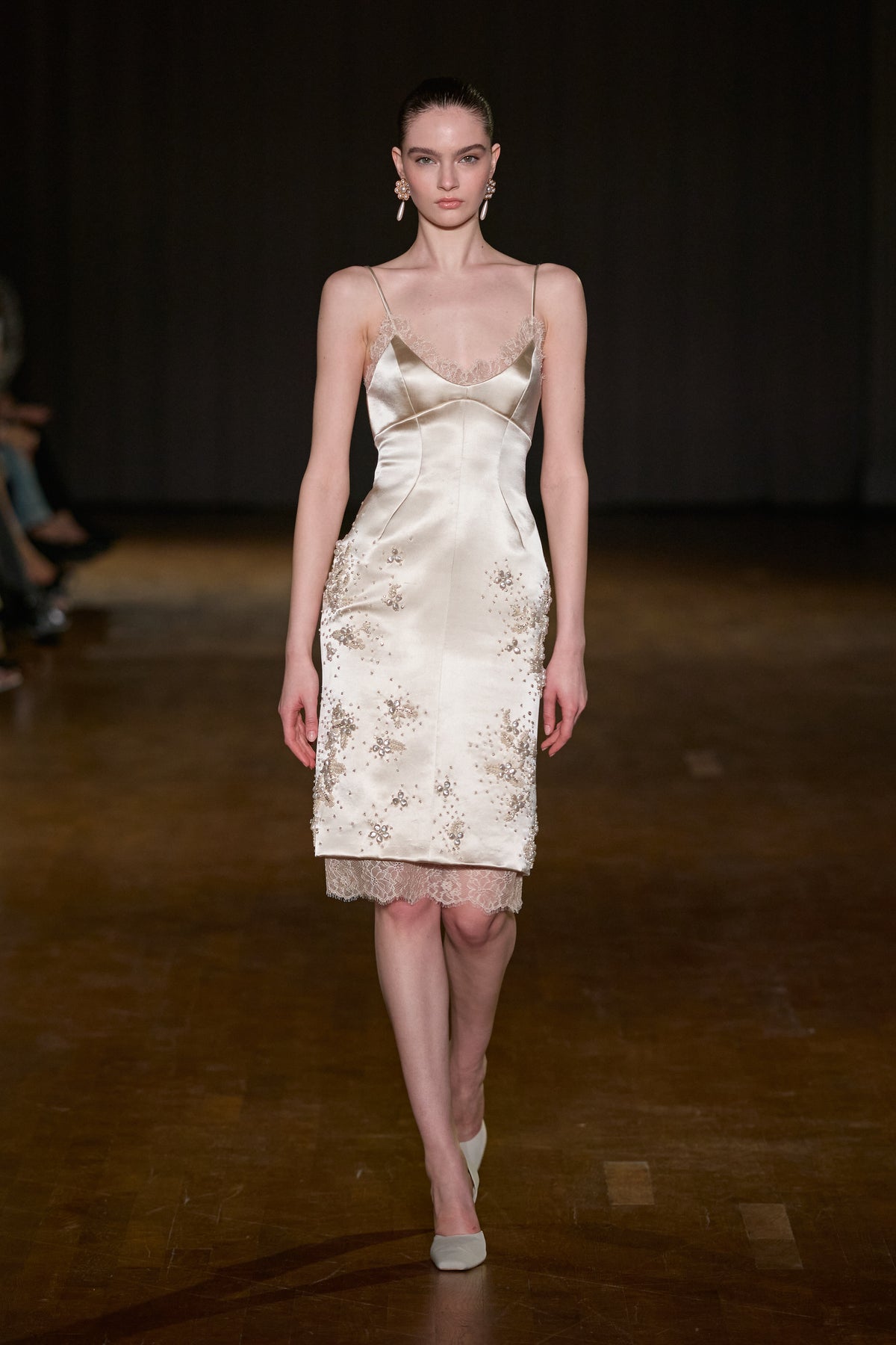 Ivory satin midi dress with thin straps, lace-trimmed neckline and hem, and scattered crystal and pearl floral embellishments.