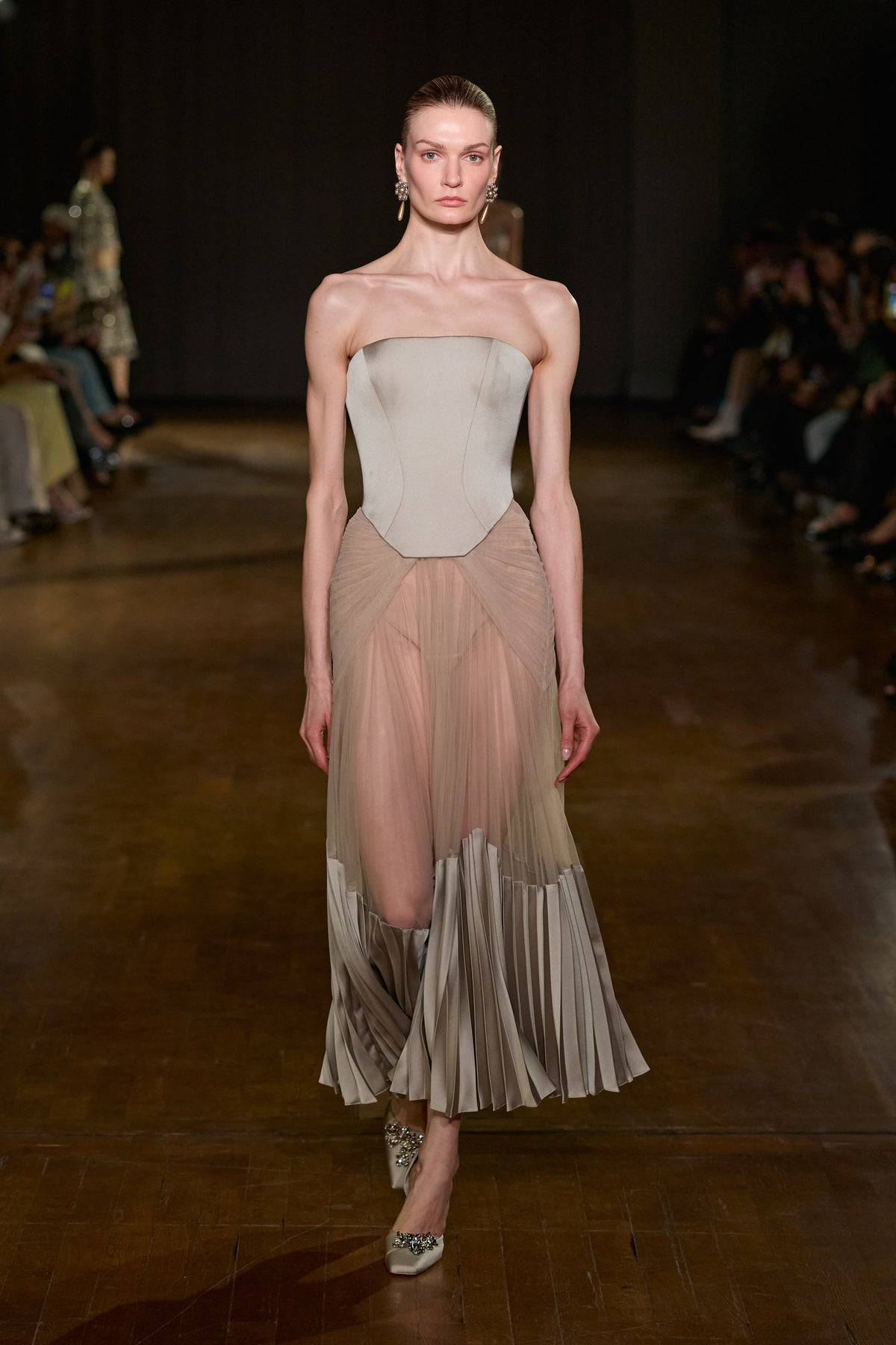 Strapless corset midi dress with sheer draped tulle skirt and sculptural pleated satin detailing along the hem.
