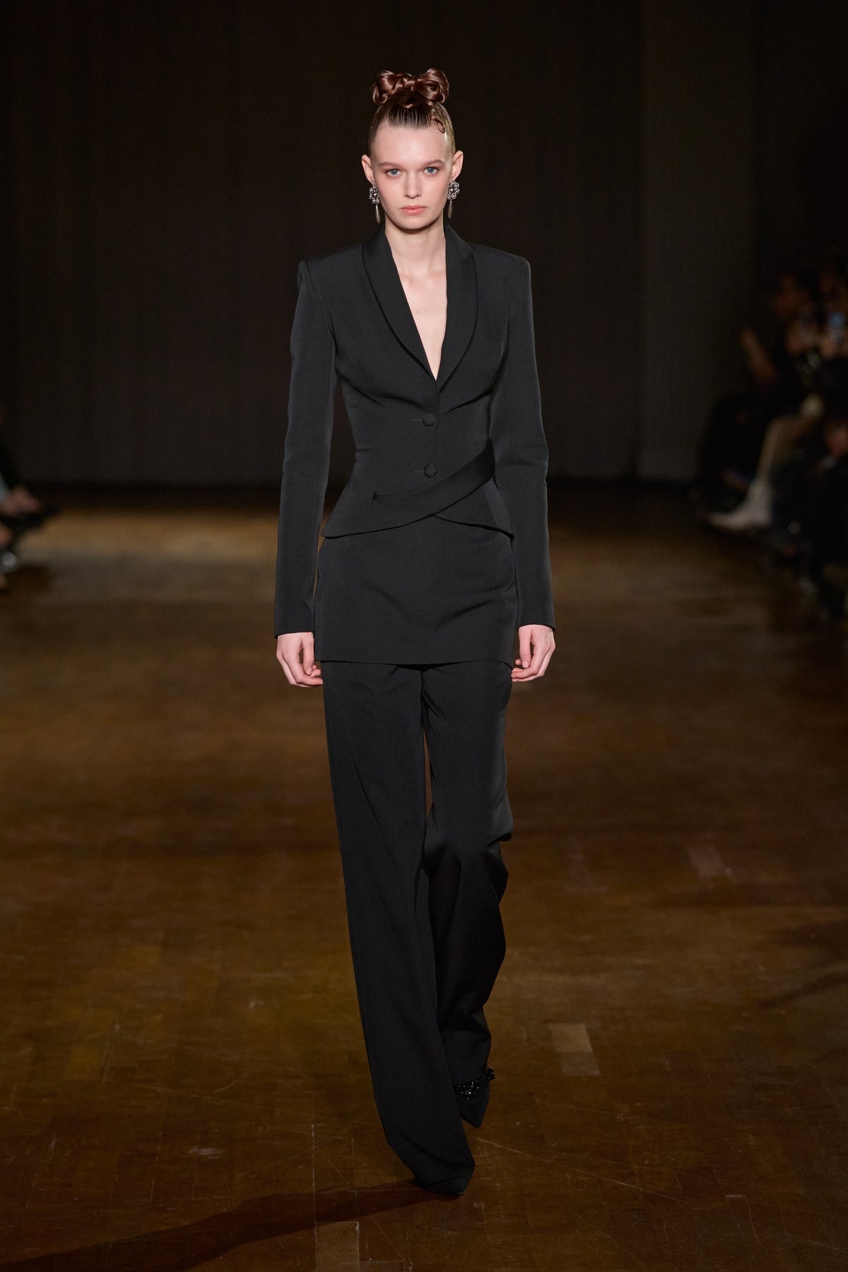 Black fitted blazer with sculpted waist, layered mini skirt, and matching tailored wide-leg trousers.