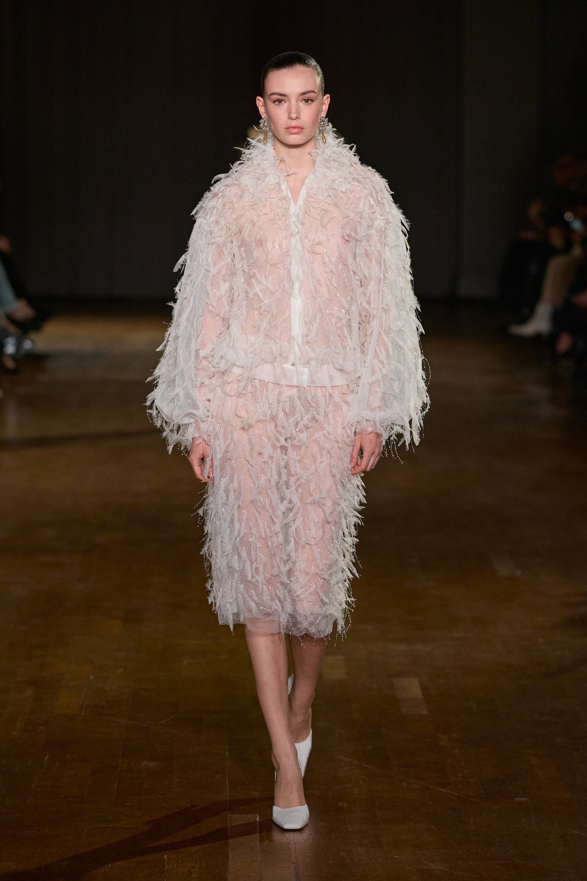 Ivory feather-textured jacket paired with a matching midi skirt featuring delicate shimmering details.