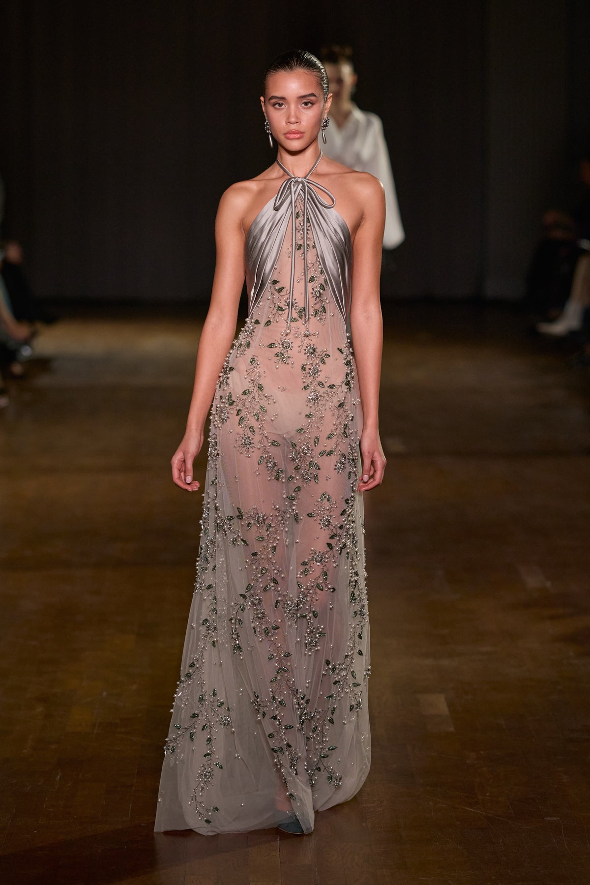 Grey sheer floor-length gown with draped satin halter neckline and intricate floral crystal embellishment.