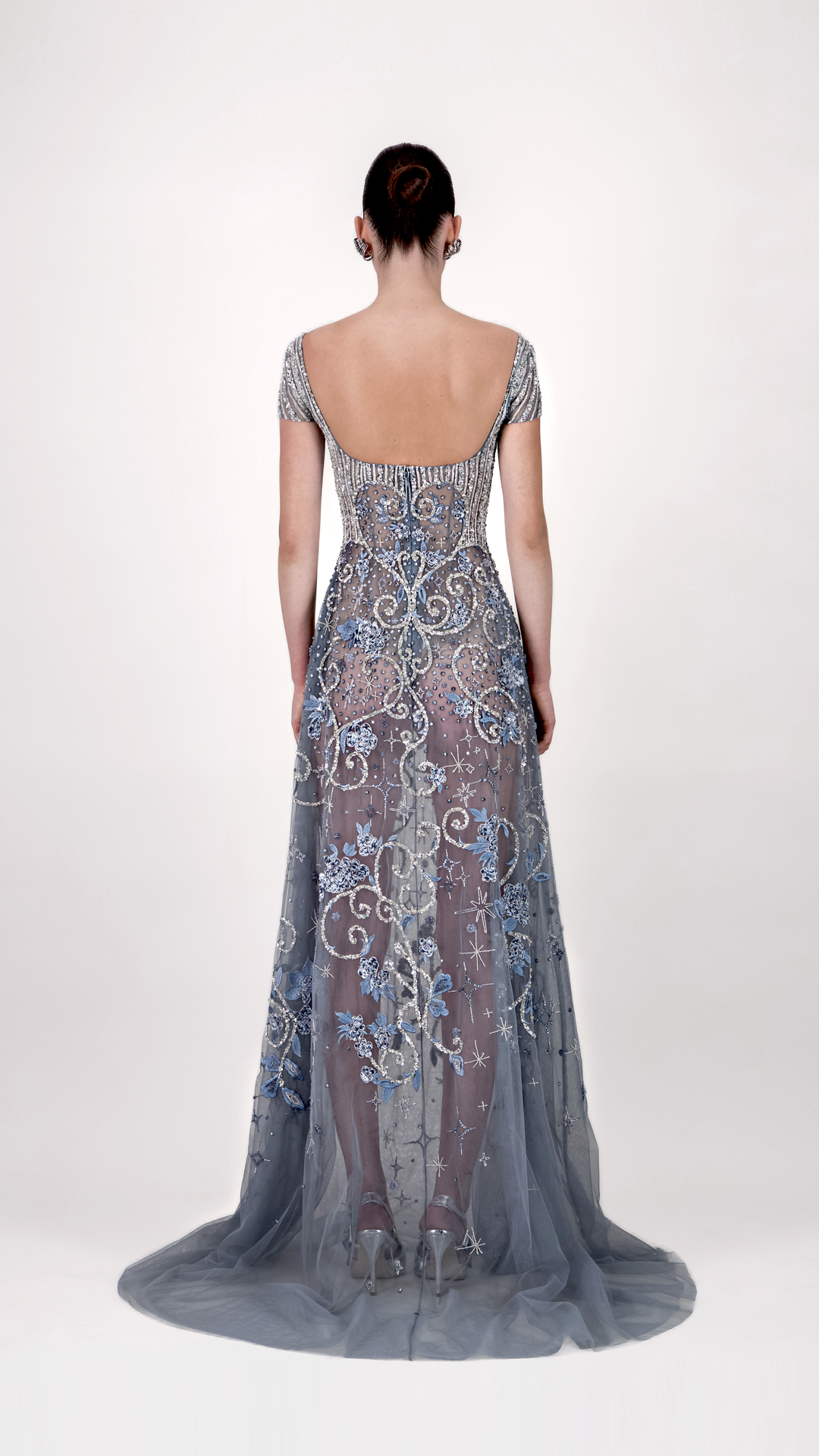 Woman wearing a long, elegant dress with intricate patterns 