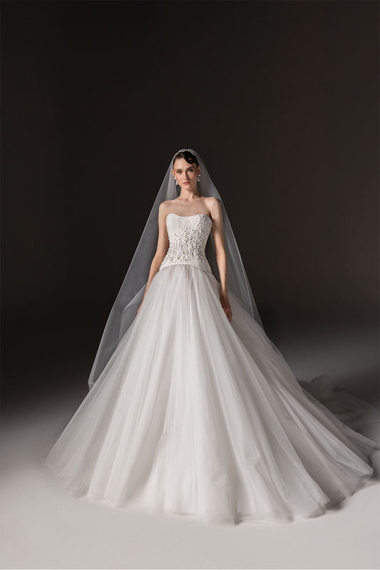 Strapless bridal gown with a sculpted crystal-embellished bodice, voluminous tulle skirt and sheer veil.