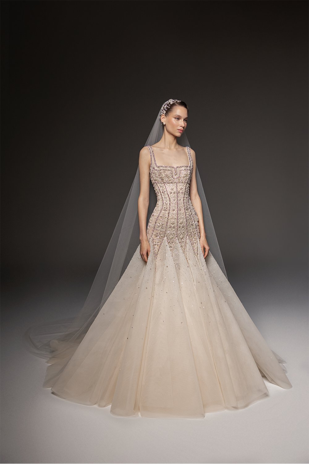 Bridal gown with a crystal-embellished corset bodice, square neckline, voluminous tulle skirt and sheer veil.