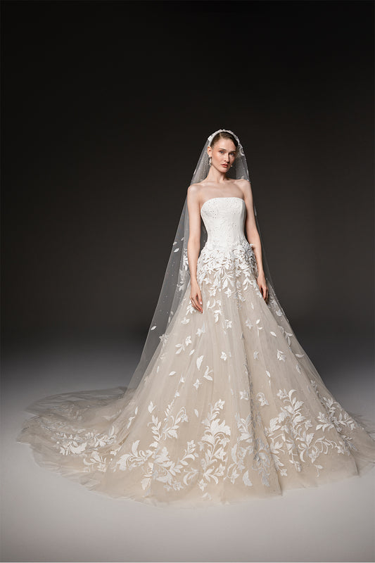 Strapless bridal gown with a sculpted bodice, voluminous tulle skirt and cascading floral embroidery.