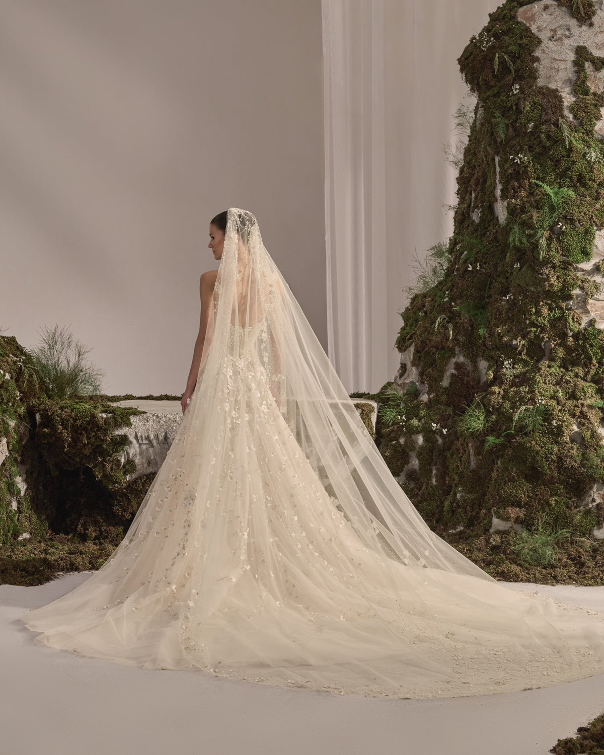 Strapless bridal gown with an embellished sculpted corset bodice, floral appliqué tulle skirt and sheer veil.