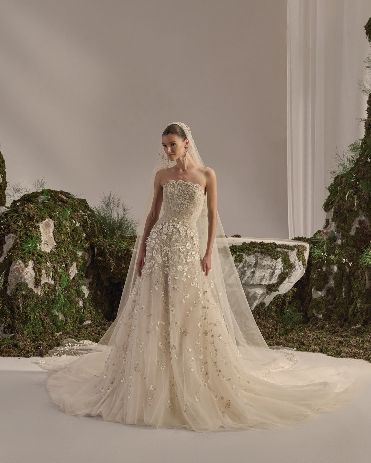 Strapless bridal gown with an embellished sculpted corset bodice, floral appliqué tulle skirt and sheer veil.