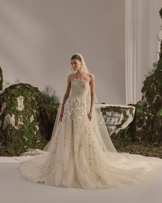 Strapless bridal gown with an embellished sculpted corset bodice, floral appliqué tulle skirt and sheer veil.