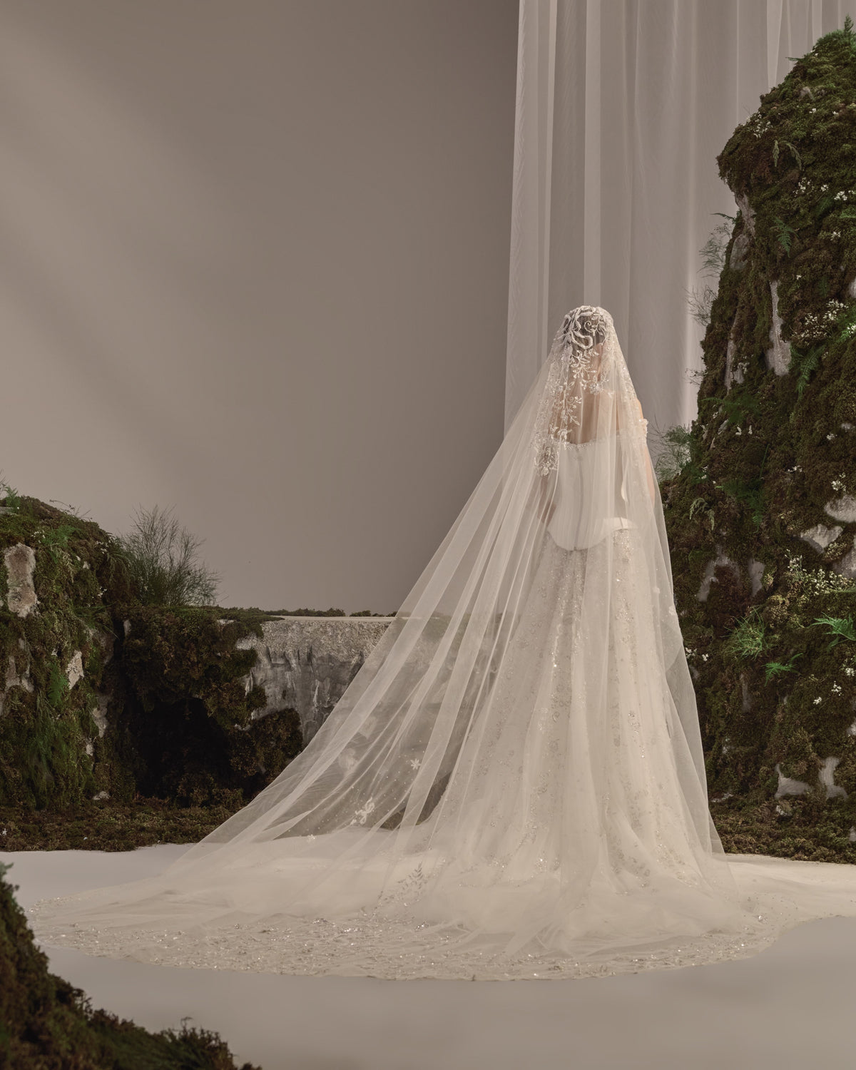 Off-shoulder bridal gown with a structured corset bodice, delicate embroidery, flowing tulle skirt and sheer veil.