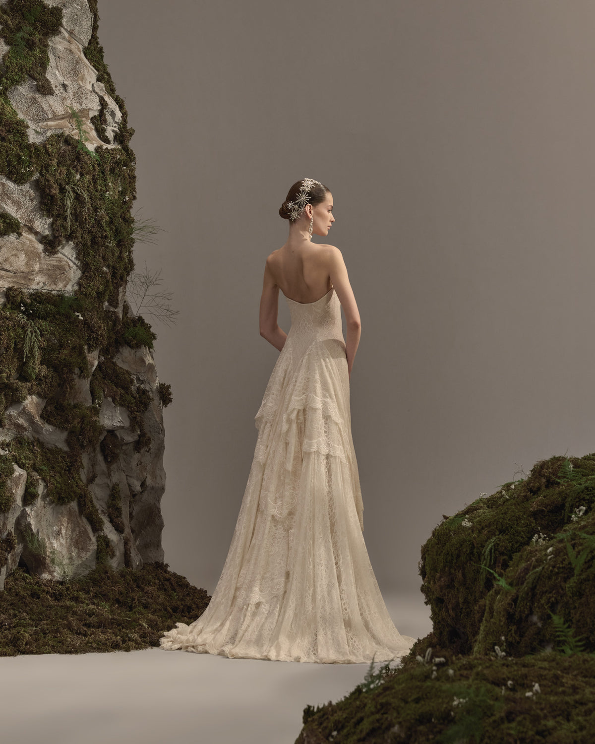 Strapless bridal gown in delicate lace with a fitted bodice, flowing asymmetrical skirt and soft train.