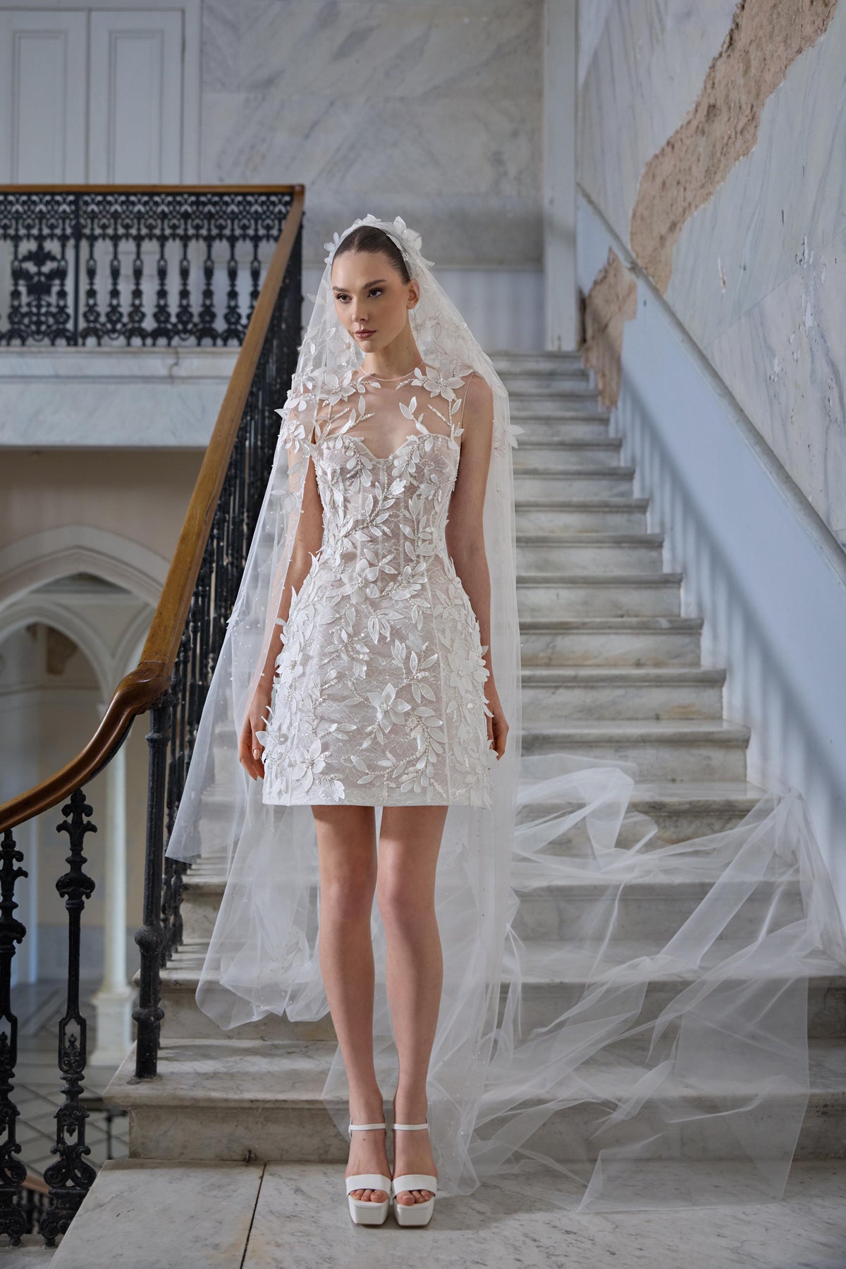Mini bridal dress with a sheer neckline, three-dimensional floral appliqués, leaf embroidery and a long sheer tulle veil.