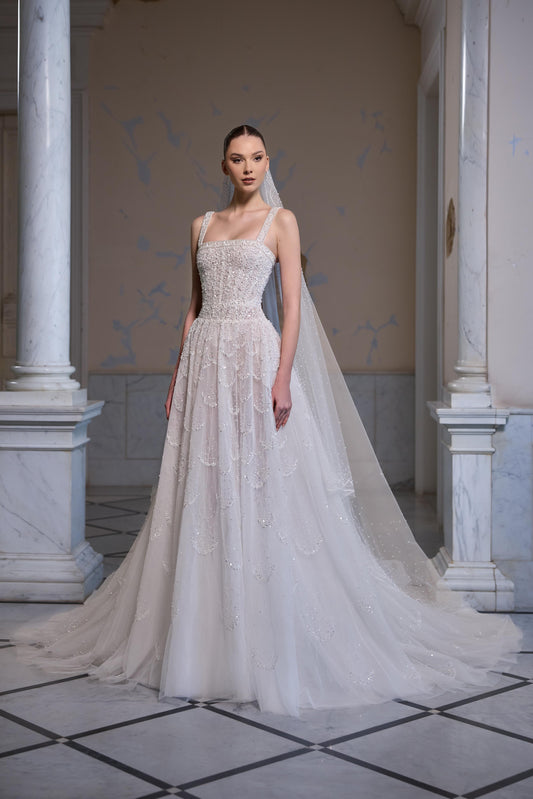 Square-neck bridal gown with an embellished fitted bodice, layered embroidered tulle skirt and sheer tulle veil.