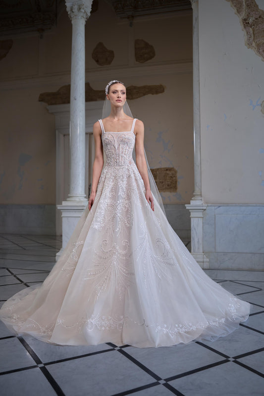 Bridal gown with a structured corset bodice, delicate straps, intricate embroidery, voluminous tulle skirt and sheer veil.