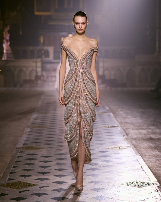 Blush pink off-shoulder couture dress with sculpted crystal embellishment and fitted silhouette.