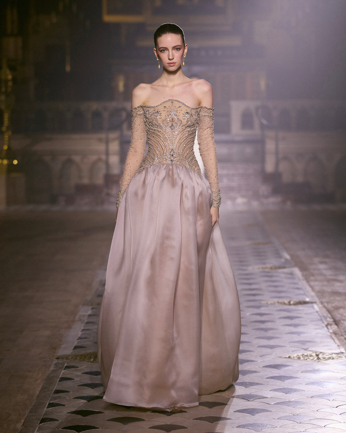 Blush pink couture gown with embellished sheer long-sleeve bodice and voluminous satin skirt.