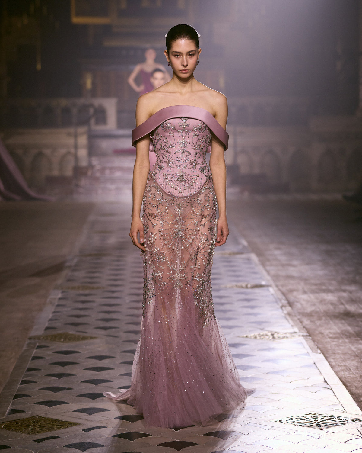 Dusty rose tulle couture gown with off-shoulder neckline and intricate crystal embellishments.