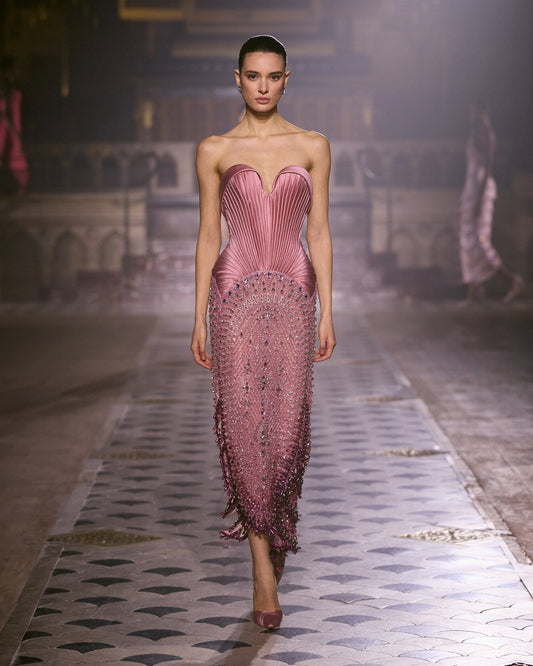 Rose pink strapless couture gown with sculpted pleated bodice and intricate crystal embellishments.