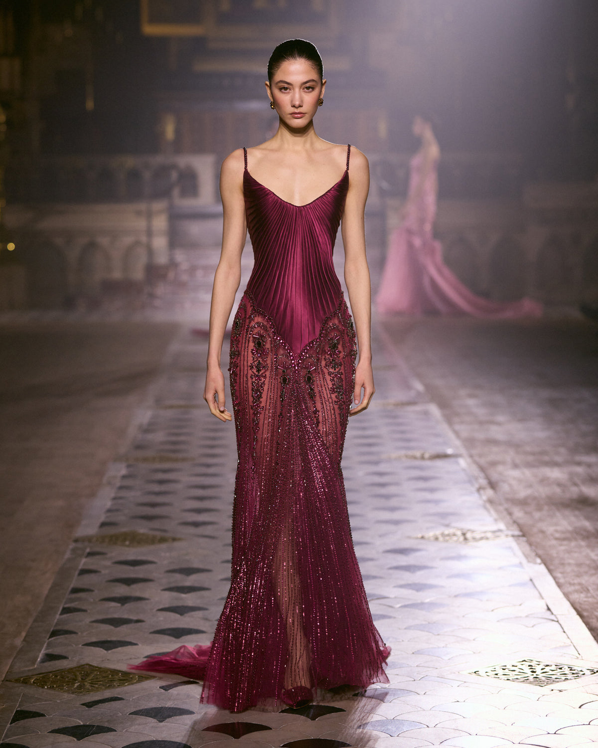 Burgundy couture gown with pleated bodice, delicate straps and intricate crystal embellishments.