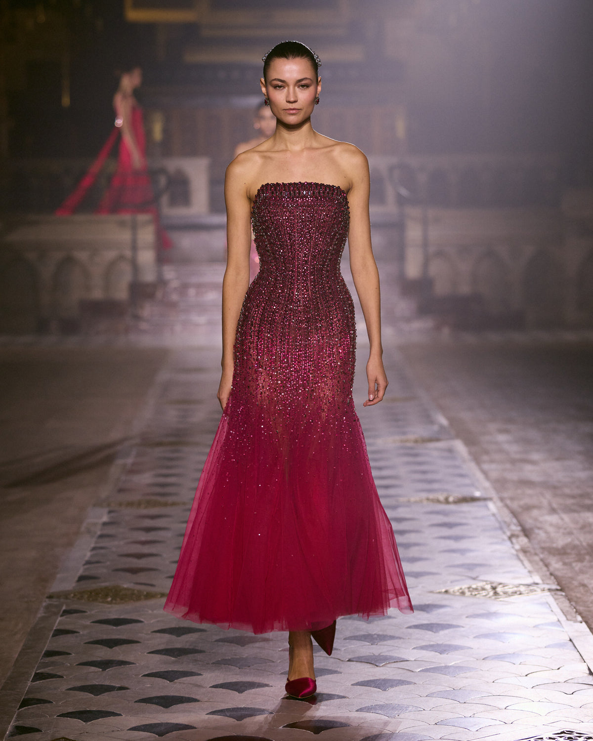 Strapless couture dress with crystal embellishments and a flowing tulle skirt.