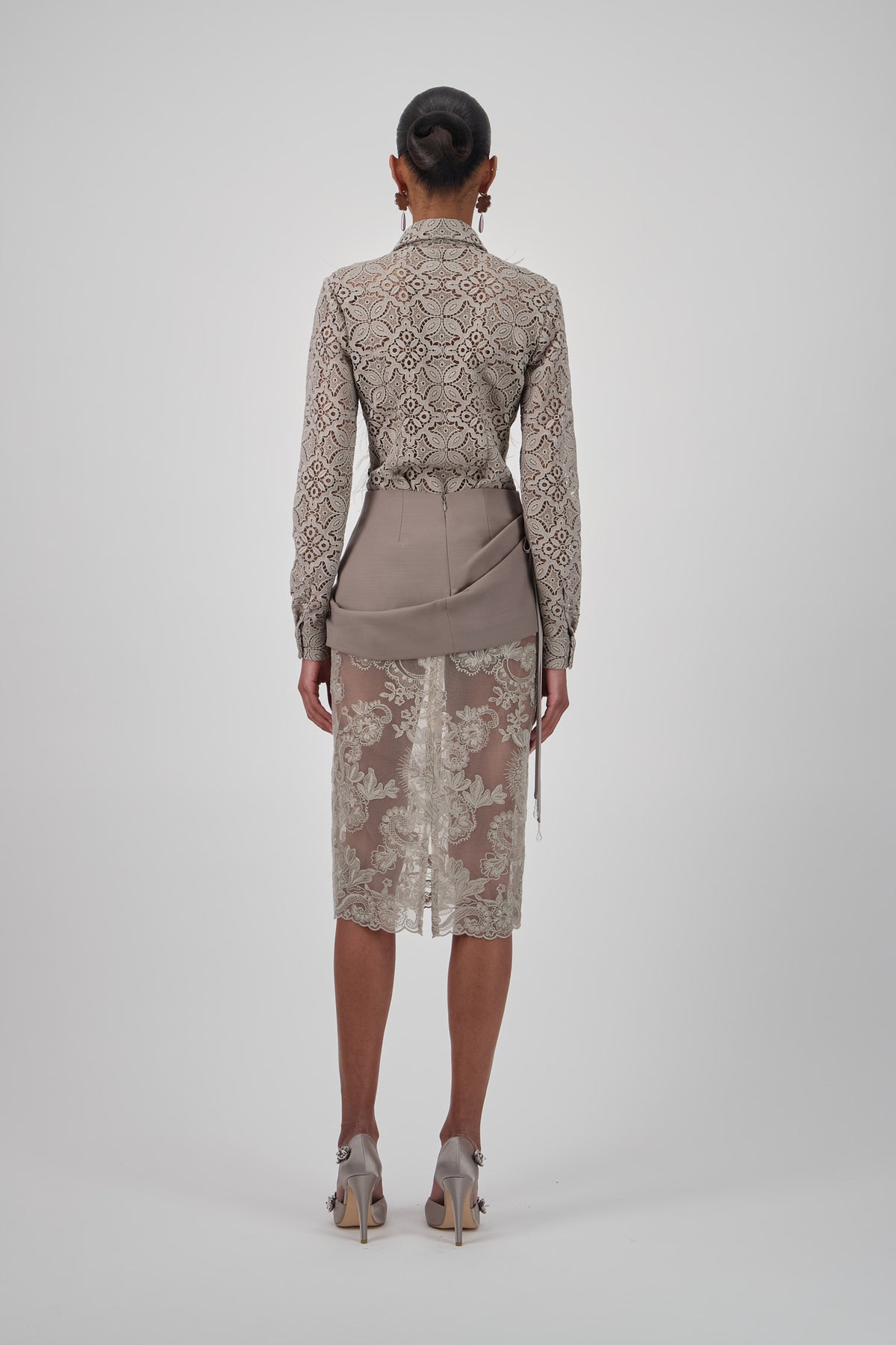 Lace floral midi skirt with a straight silhouette, intricate floral embroidery and scalloped hem.
Lace shirt with long sleeves, pointed collar, shimmering embellished front panel and soft feather trim.