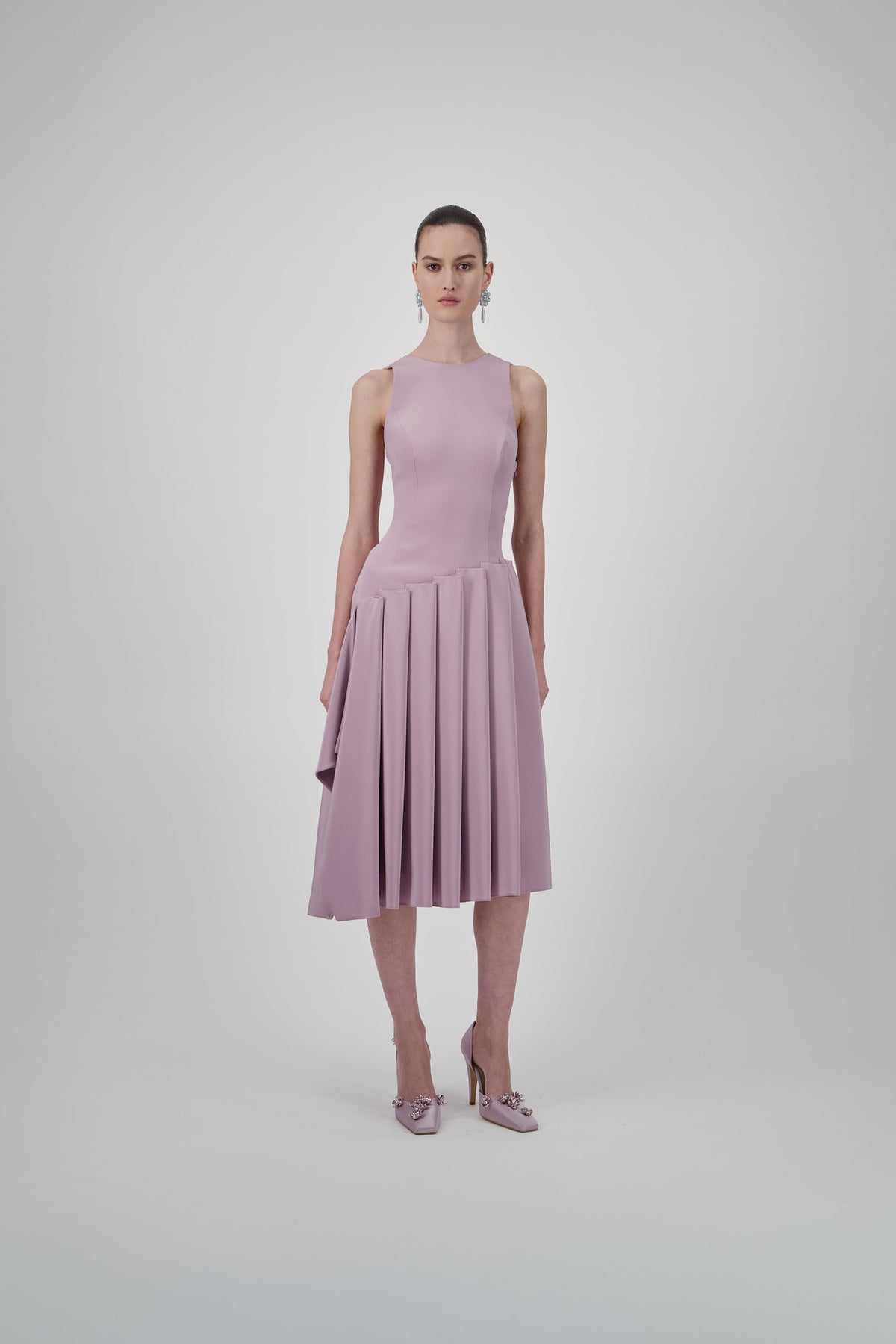 Ice pink sleeveless midi dress with a fitted bodice, dropped waist and asymmetrical pleated skirt.