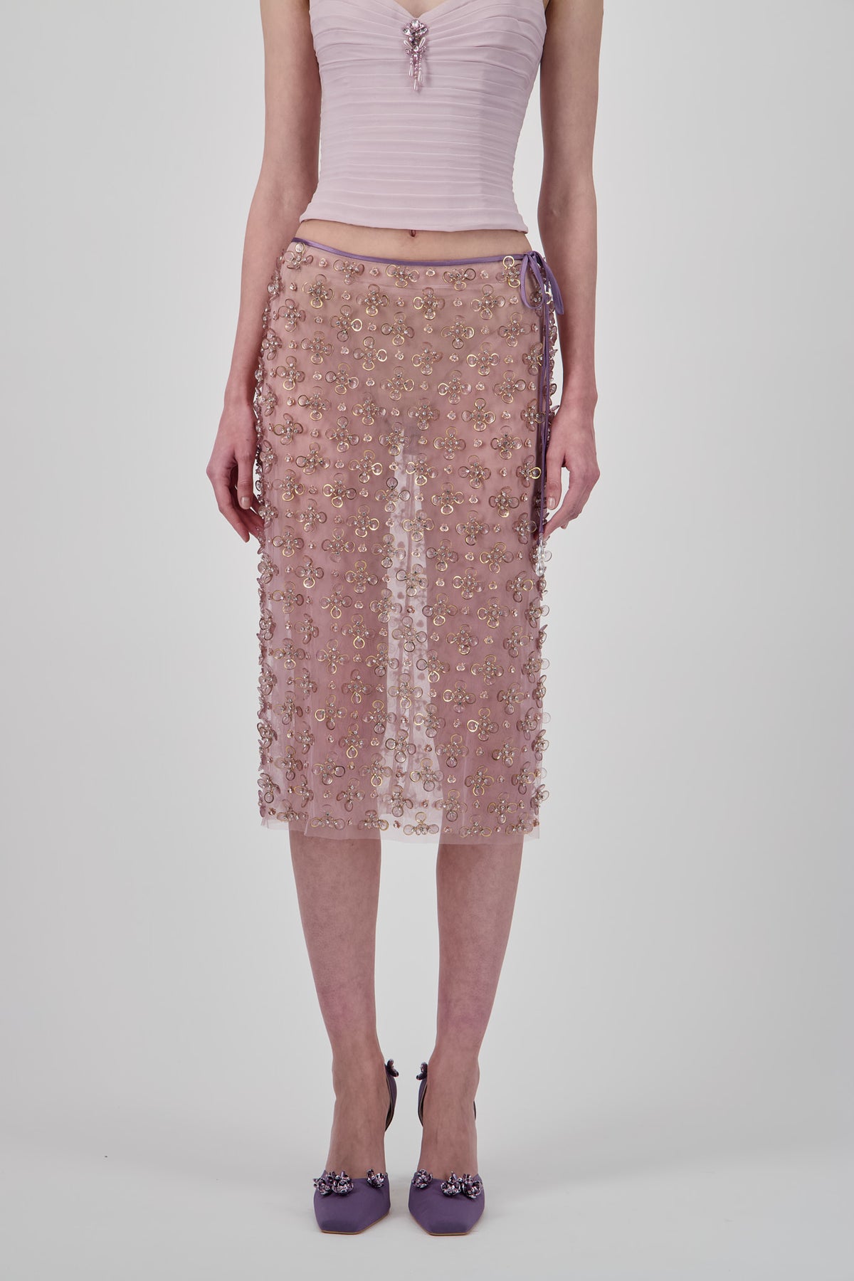 Beaded tulle short skirt with intricate floral embellishments, sheer detailing and a straight silhouette.
Draped georgette top with delicate shoulder straps, softly gathered detailing and an embellished center accent.