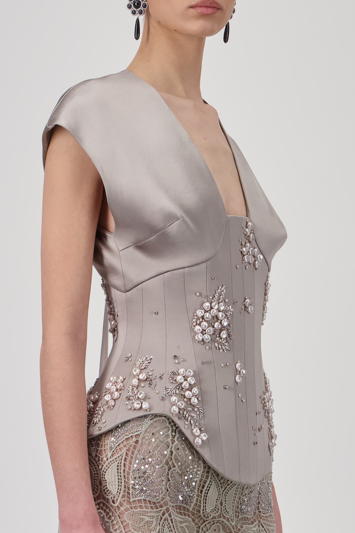 Sculpted corset top with floral embellishments, structured paneling and draped cap-sleeve detailing.