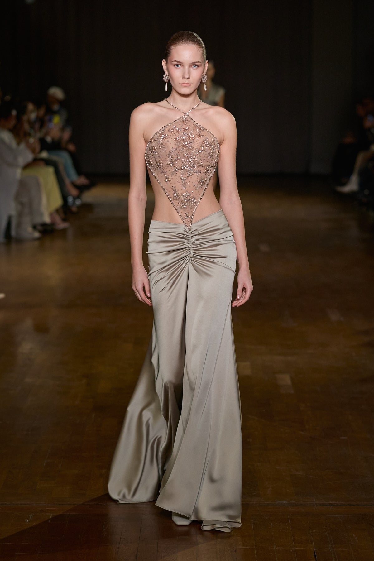 Floor-length gown with crystal-embellished sheer tulle bodice and draped satin skirt with gathered waist detailing.