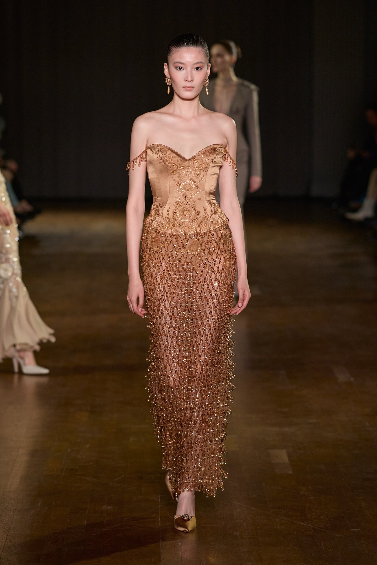 Bronze satin corset gown with sweetheart neckline, intricate embroidery, beaded details, and a shimmering floor-length embellished skirt.