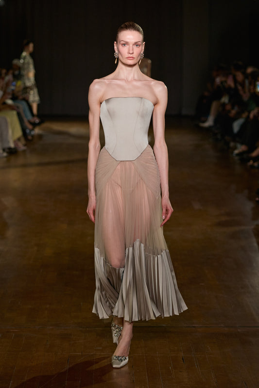 Strapless corset midi dress with sheer draped tulle skirt and sculptural pleated satin detailing along the hem.