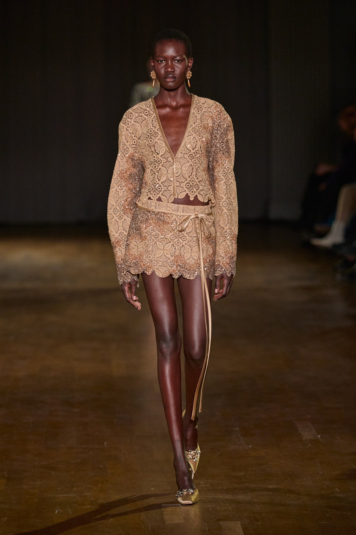 Beige lace jacket and matching mini skirt with shimmering embellishments, scalloped edges, and delicate tie detailing.