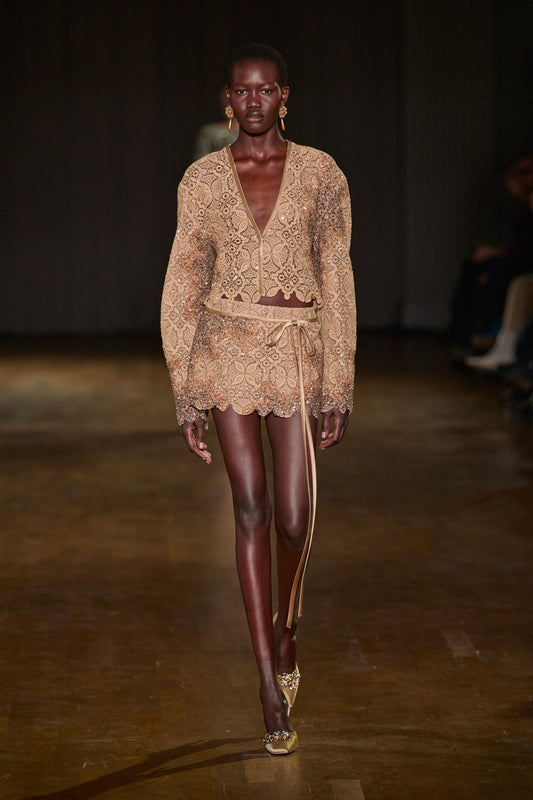 Beige lace jacket and matching mini skirt with shimmering embellishments, scalloped edges, and delicate tie detailing.