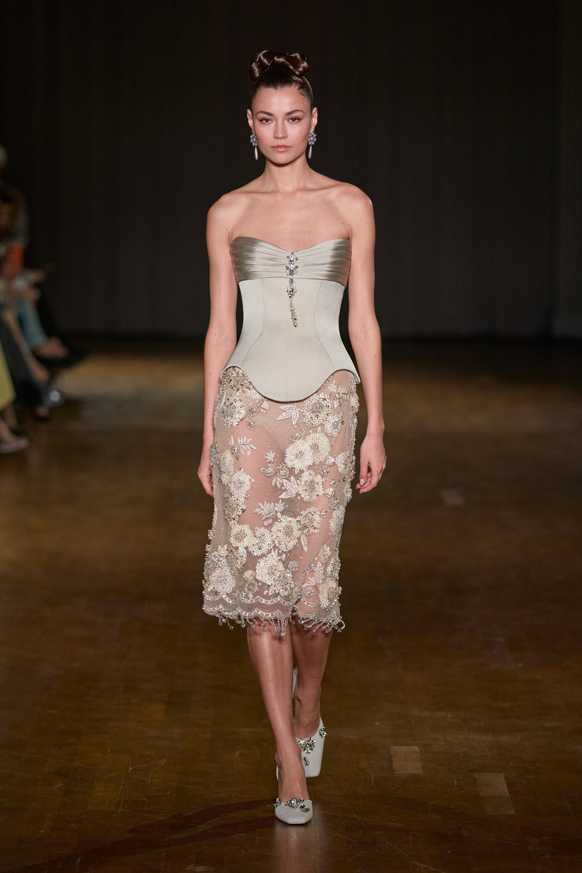Strapless corset top with pleated satin bust and jeweled detail, paired with a sheer floral-embroidered midi skirt with beaded embellishments.