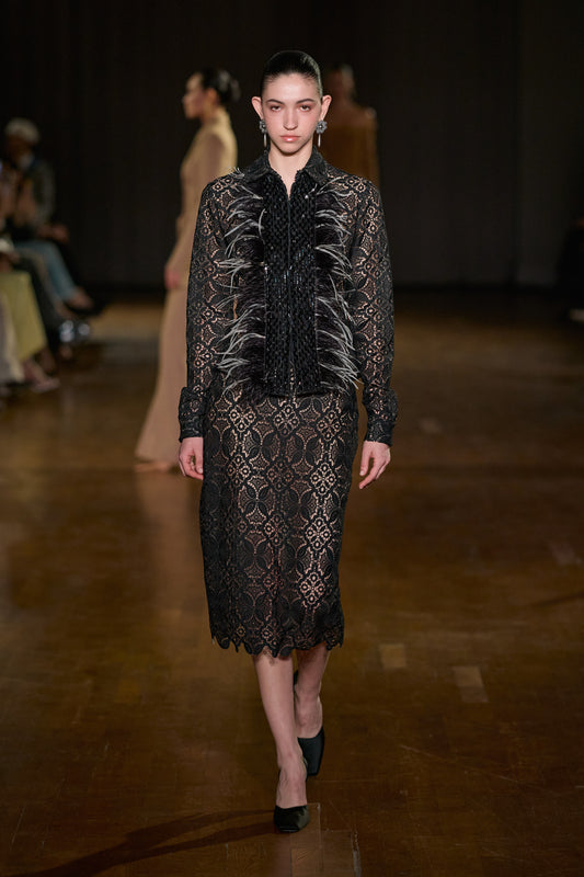Black lace long-sleeve shirt with feather and sequin detailing, paired with a matching floral lace midi skirt.