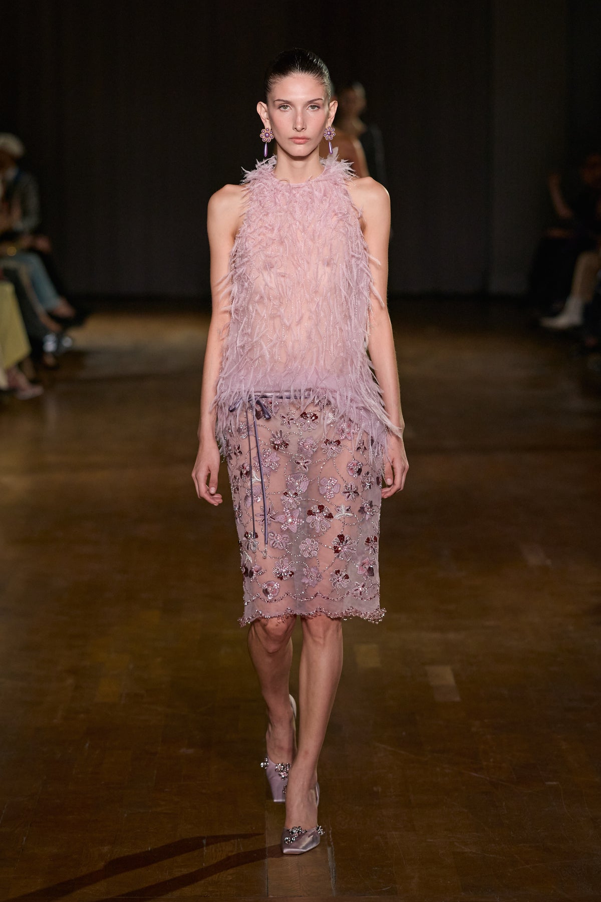 Pink feathered sleeveless top paired with a sheer midi skirt featuring intricate floral embroidery and shimmering embellishments.