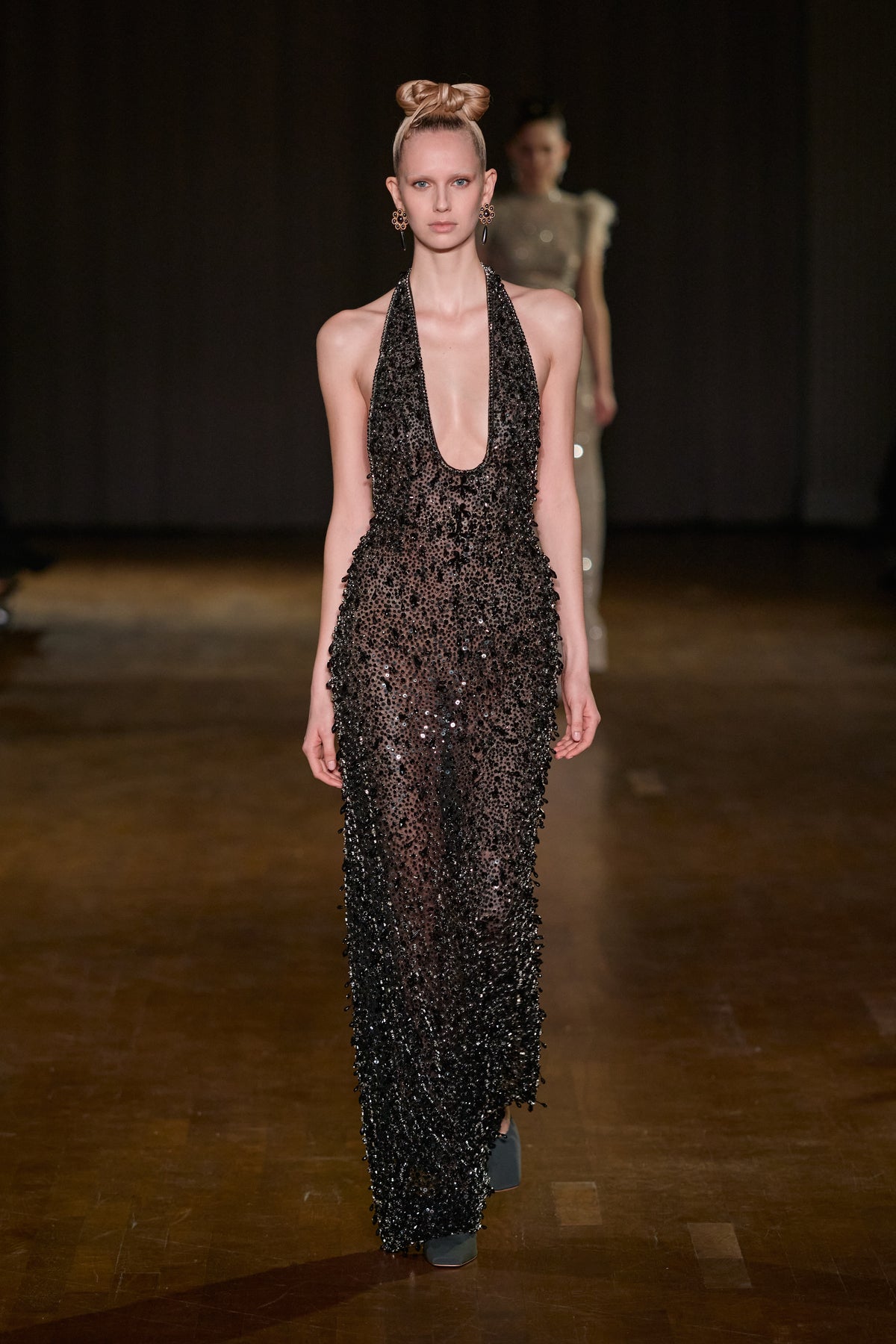 Black halter-neck gown with a plunging neckline and all-over crystal and sequin embellishments.