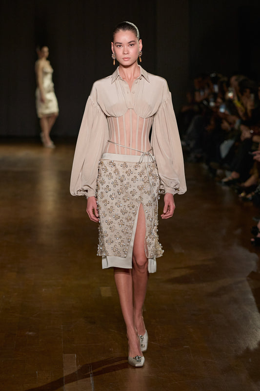 Sheer corset shirt with draped bust and long sleeves, paired with a crystal floral-embellished midi skirt with front slit.
