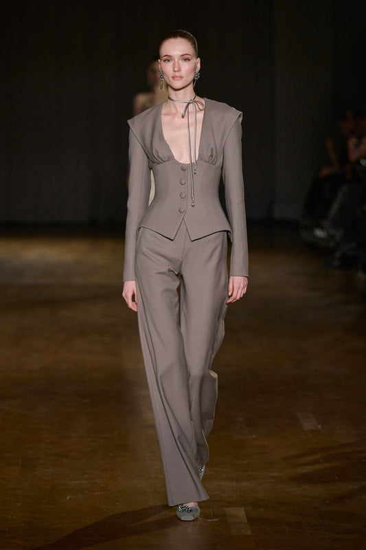 Taupe structured corset jacket with plunging neckline and button details, paired with matching tailored wide-leg trousers.